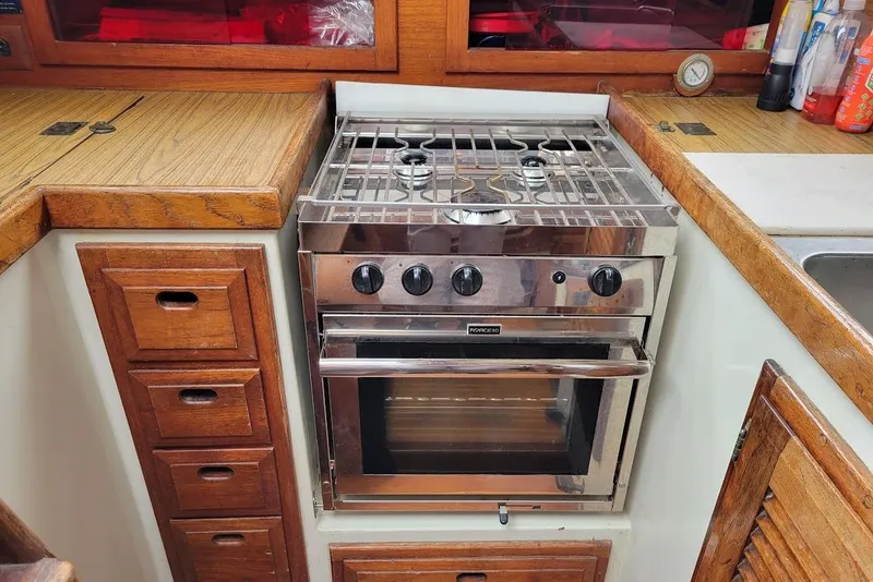 Slide: The Image of Vintage yacht kitchen with stainless steel stove, wooden cabinetry, and countertop. - 12