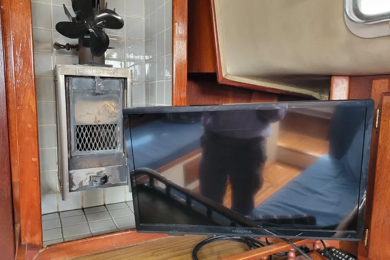 Slide: The Image of 1976 Down East Yachts Cutter interior with stove and Insignia TV. - 18