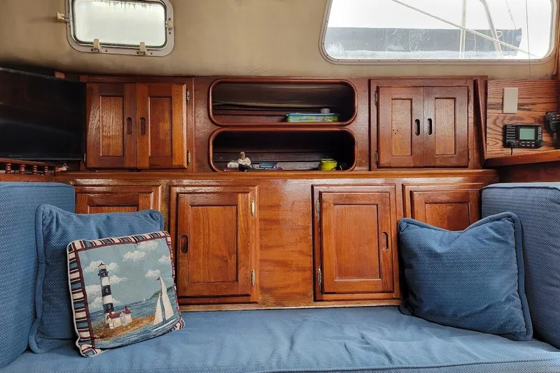 Slide: The Image of 1976 Down East Yachts Cutter interior with wooden cabinets and blue cushions. - 20
