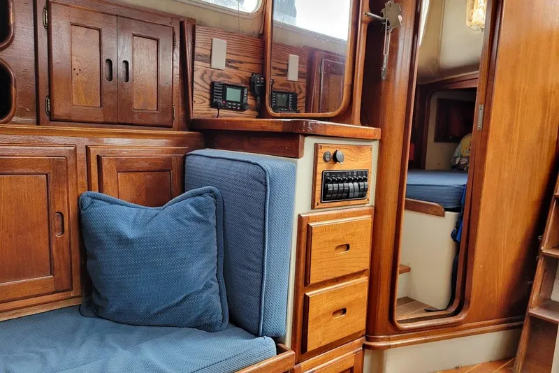 Slide: The Image of 1976 Down East Yachts Cutter interior with wooden cabinetry and blue cushions. - 22