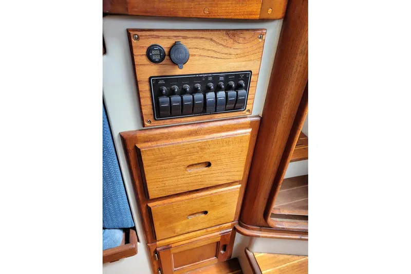 Slide: The Image of 1976 Down East Yachts Cutter interior with wooden panel and electrical switches. - 23