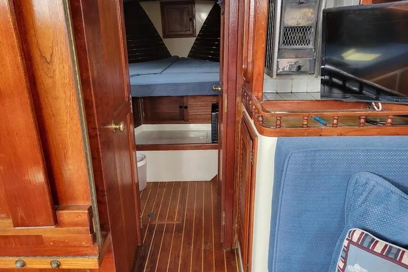 Slide: The Image of 1976 Down East Yachts Cutter interior with wood finish, cozy cabin, and modern amenities. - 26