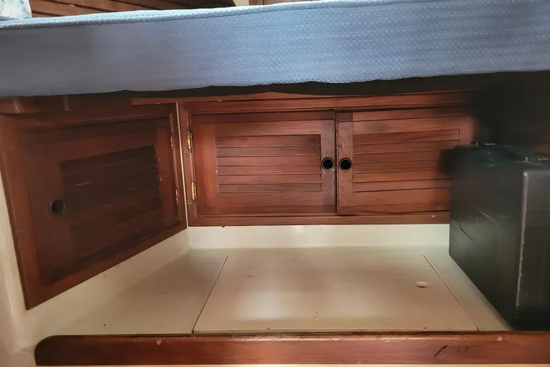 Slide: The Image of Interior of 1976 Down East Yachts Cutter with wooden cabinets and storage space. - 28