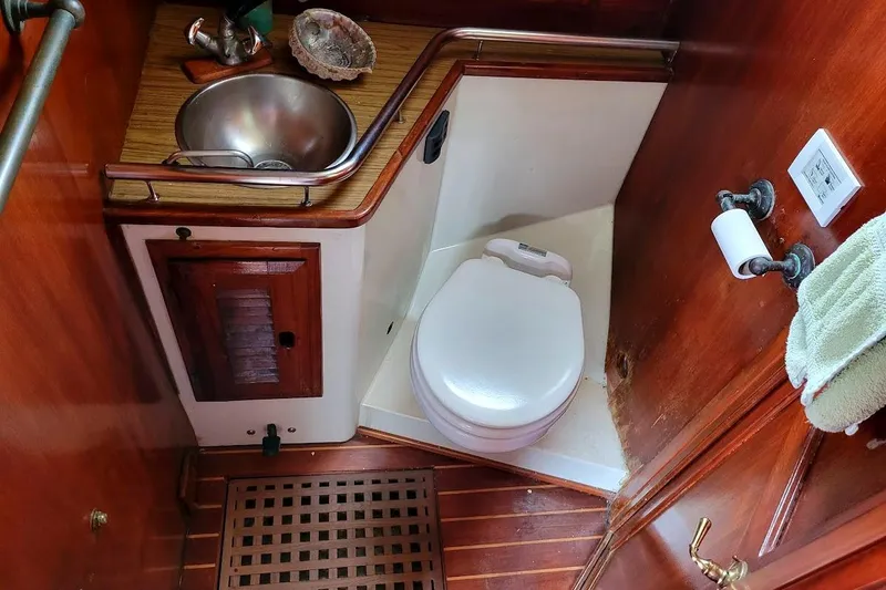 Slide: The Image of 1976 Down East Yachts Cutter bathroom with sink, toilet, and wooden cabinetry. - 31
