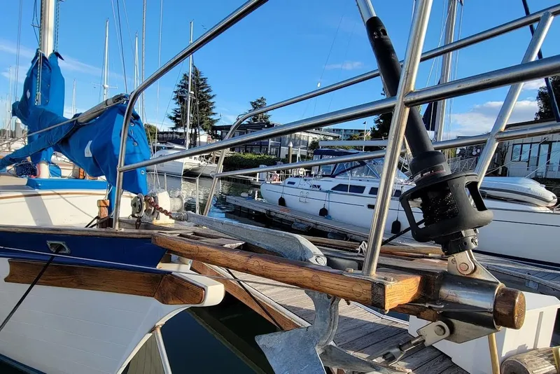Slide: The Image of 1976 Down East Yachts Cutter sailboat docked, featuring blue sail cover and wooden details. - 4