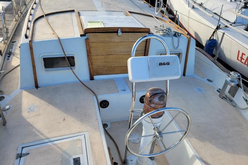 Slide: The Image of 1976 Down East Yachts Cutter sailboat deck with steering wheel and navigation equipment. - 8