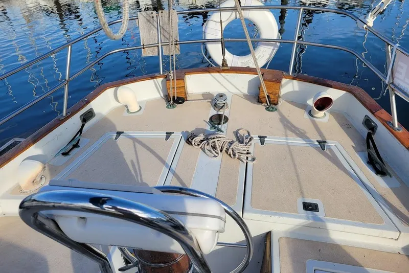 Slide: The Image of 1976 Down East Yachts Cutter deck with steering wheel, rope, and life preserver. - 9