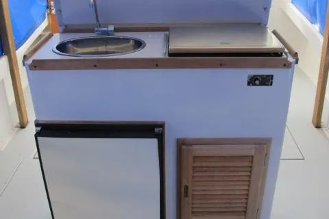 Slide: The Image of 2010 Ellis Downeast Picnic Boat kitchenette with sink, fridge, and storage. - 4