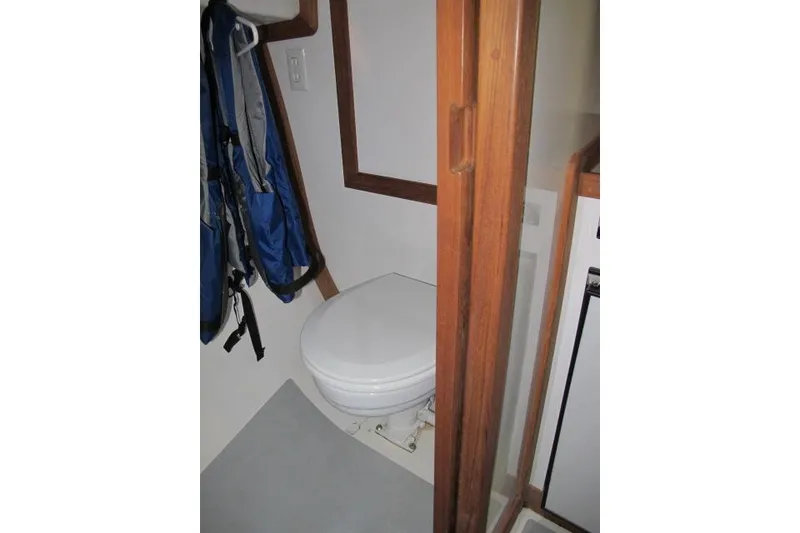 Slide: The Image of 2010 Ellis Downeast Picnic Boat interior bathroom with wooden door and compact toilet. - 5
