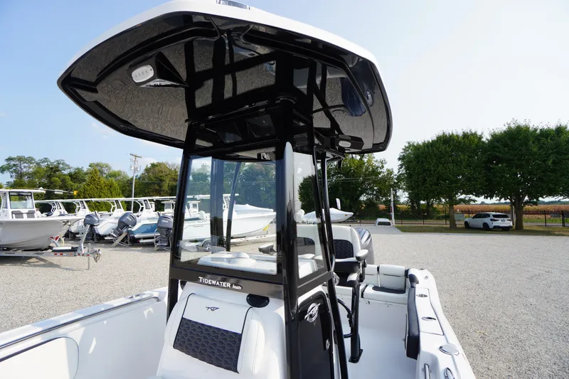 Slide: The Image of 2026 Tidewater 210 LXF boat with T-top, parked in a marina lot. - 11