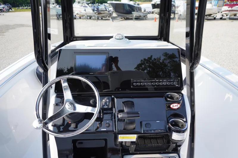 Slide: The Image of 2026 Tidewater 210 LXF boat dashboard with steering wheel and control panel. - 16
