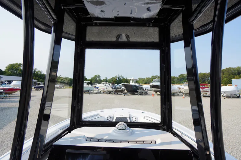 Slide: The Image of 2026 Tidewater 210 LXF boat interior view at a marina with parked boats. - 19