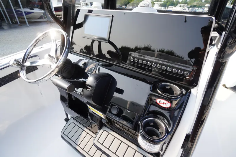 Slide: The Image of 2026 Tidewater 210 LXF boat dashboard with steering wheel and control panel. - 24