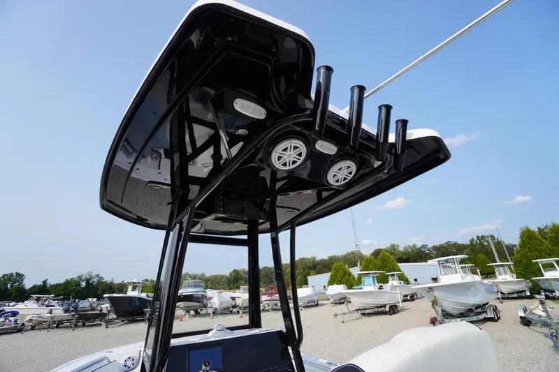 Slide: The Image of 2026 Tidewater 210 LXF boat with T-top and rod holders in a marina setting. - 32