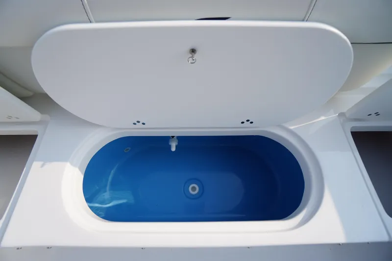 Slide: The Image of Livewell compartment on 2026 Tidewater 210 LXF boat, featuring a blue interior. - 40