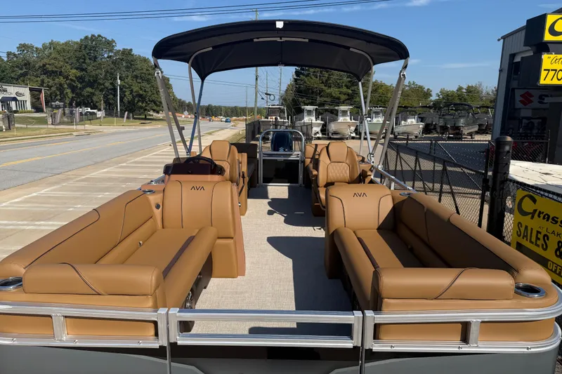 Slide: The Image of 2026 Avalon VENTURE QUAD LOUNGER pontoon boat with tan seating and canopy, parked outdoors. - 9