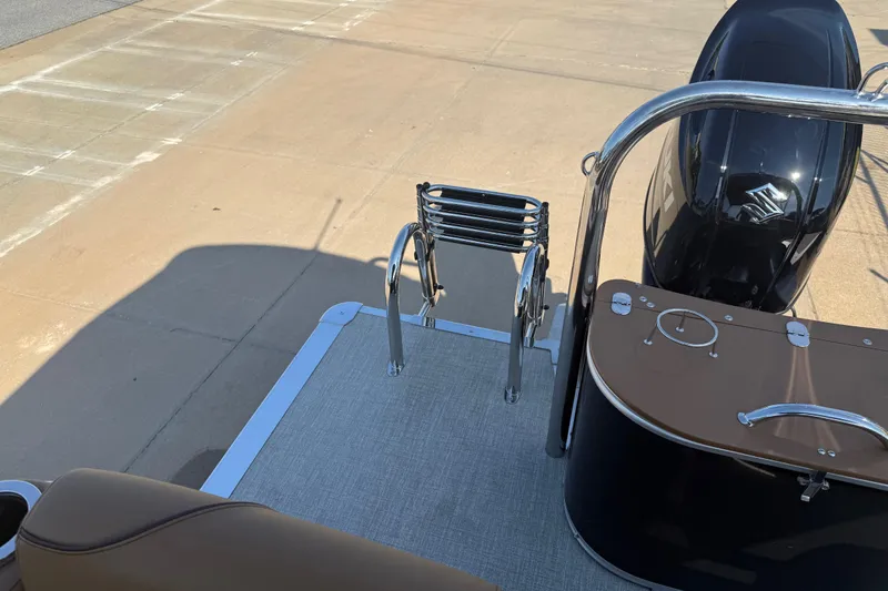 Slide: The Image of 2026 Avalon VENTURE QUAD LOUNGER boat with ladder and motor, docked on concrete. - 17