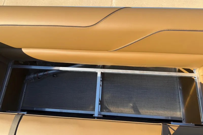 Slide: The Image of 2026 Avalon VENTURE QUAD LOUNGER seat storage compartment with tan upholstery and metal frame. - 32