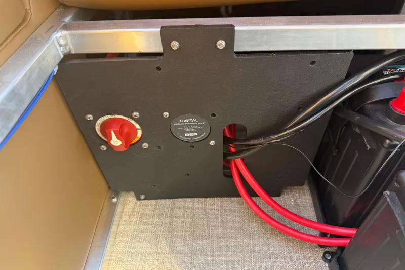 Slide: The Image of Battery compartment of 2026 Avalon VENTURE QUAD LOUNGER with red cables and control panel. - 36