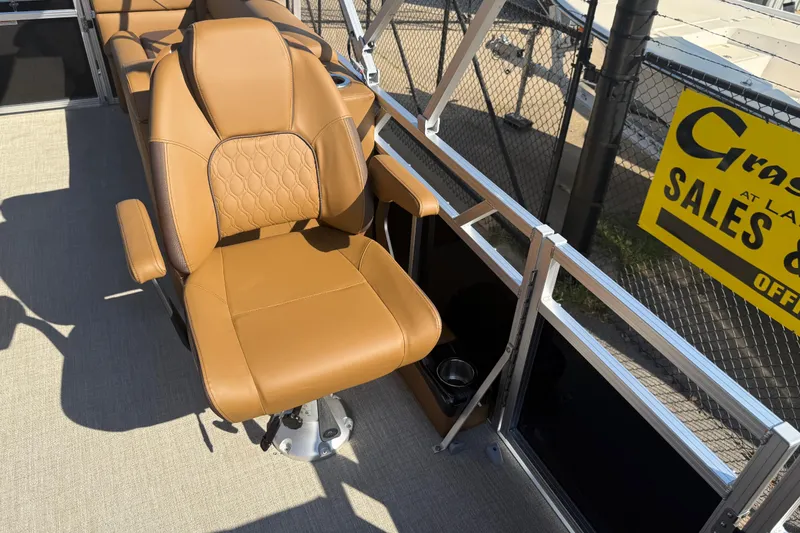 Slide: The Image of Luxurious tan seating on 2026 Avalon VENTURE QUAD LOUNGER boat, featuring cup holder and armrests. - 29
