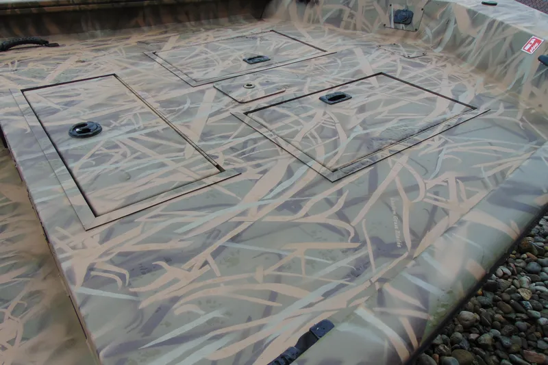 Slide: The Image of 2026 CRESTLINIER 1860 Retriever Deluxe Tiller boat with camouflage pattern and storage compartments. - 5