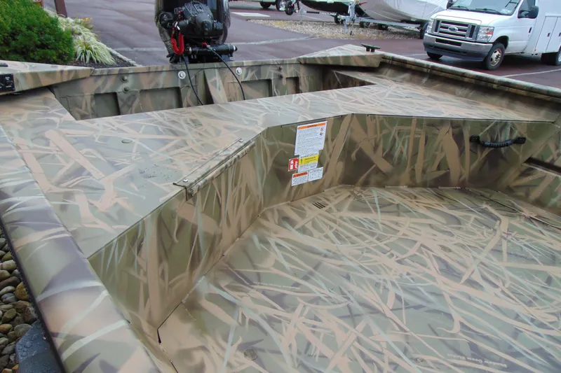 Slide: The Image of 2026 CRESTLINIER 1860 Retriever Deluxe Tiller boat with camouflage design in a parking area. - 7