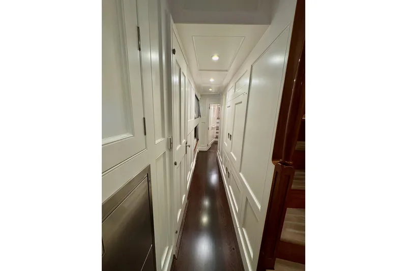 Slide: The Image of Narrow hallway inside 2009 Brooklin Boat Yard model, featuring elegant wood paneling and soft lighting. - 38