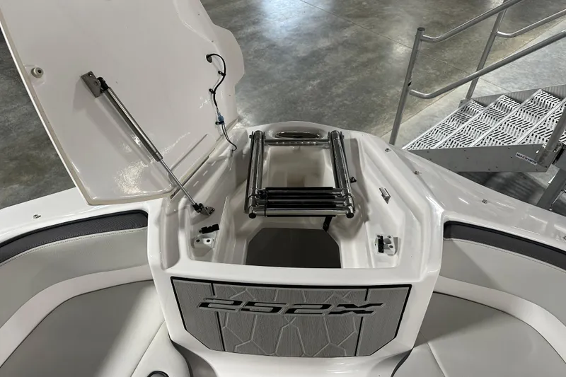 Slide: The Image of 2024 Yamaha Boats 252XE bow storage with ladder, open hatch, and sleek interior design. - 15