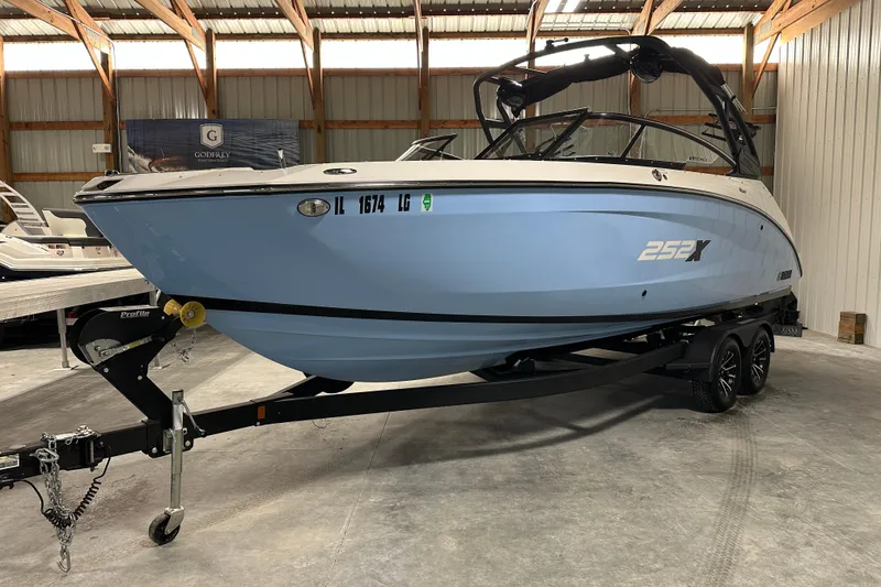 Slide: The Image of 2024 Yamaha Boats 252XE in a showroom, featuring sleek design and modern trailer. - 2