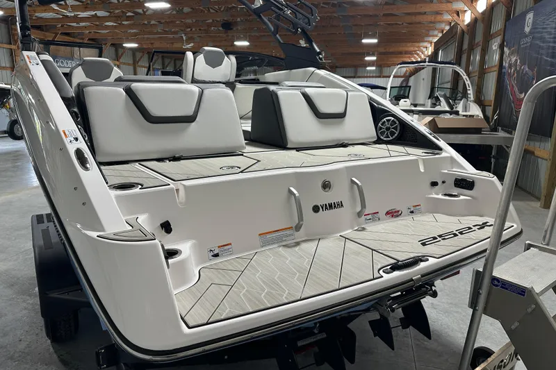 Slide: The Image of 2024 Yamaha Boats 252XE, sleek design, spacious seating, modern features, in a showroom setting. - 6
