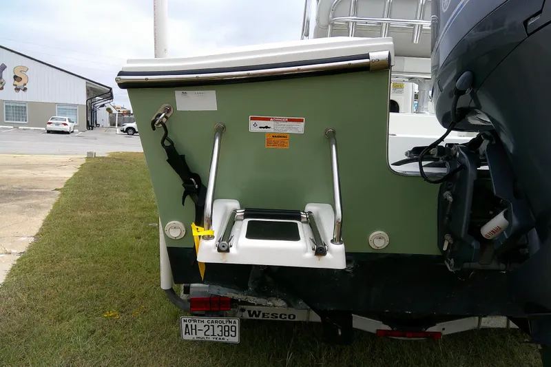 Slide: The Image of 2016 Parker 2100 Special Edition boat with ladder and motor, parked on grass. - 8