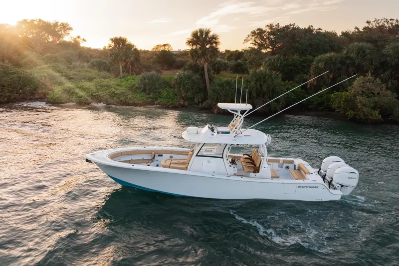 The Image of 2026 Sportsman Open 352 Center Console boat cruising near lush shoreline at sunset. - 1