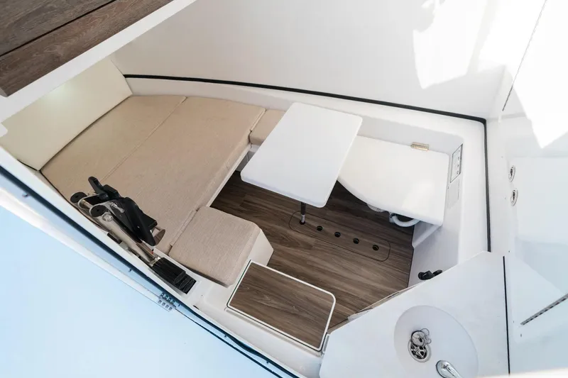 Slide: The Image of 2026 Sportsman Open 352 Center Console cabin interior with seating, table, and wood flooring. - 19