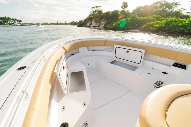 Slide: The Image of 2026 Sportsman Open 352 Center Console boat interior with tan seating, on a scenic waterway. - 4