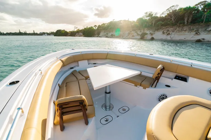 Slide: The Image of 2026 Sportsman Open 352 Center Console boat with luxurious seating and table, cruising on serene waters. - 5