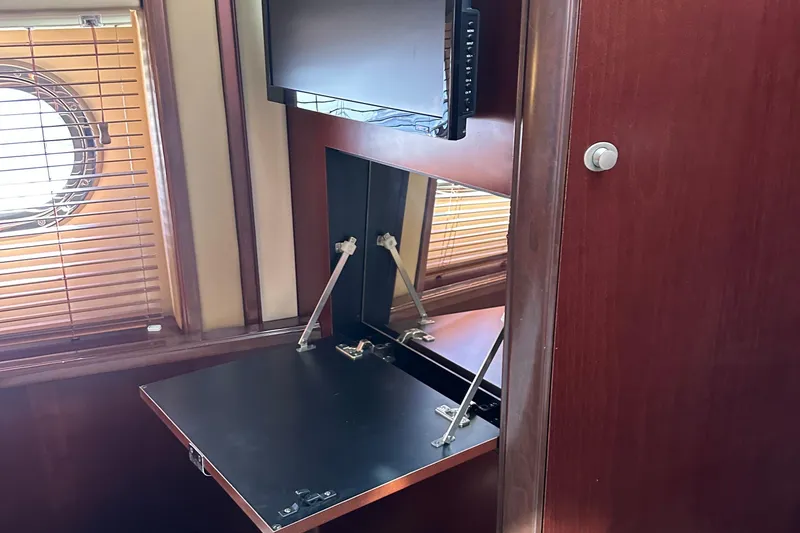 Slide: The Image of 2005 Sea Ray 500 Sedan Bridge interior with fold-out desk and porthole window. - 20