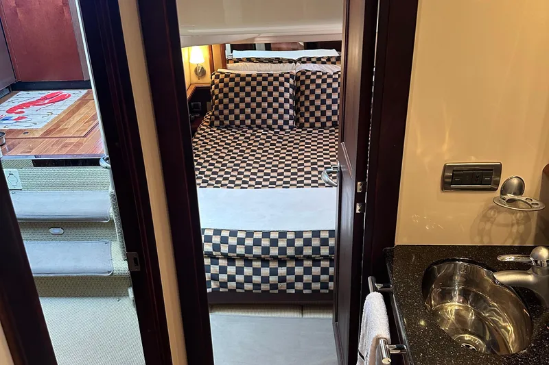 Slide: The Image of Interior of 2005 Sea Ray 500 Sedan Bridge, featuring a cozy bedroom and modern bathroom. - 22