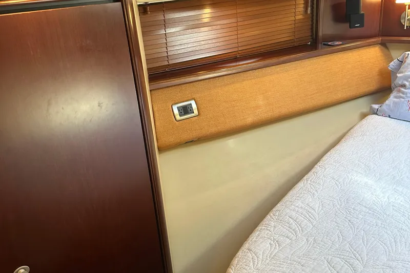 Slide: The Image of Interior cabin of 2005 Sea Ray 500 Sedan Bridge with wood paneling and bedding. - 25