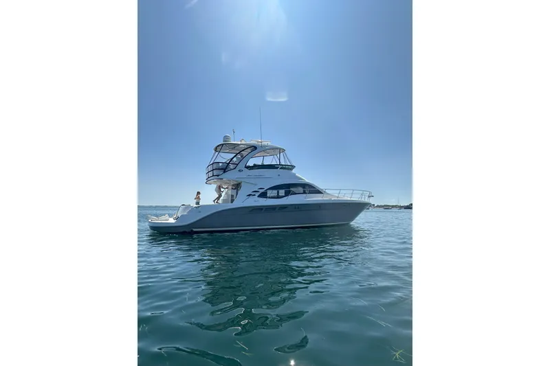 Slide: The Image of 2005 Sea Ray 500 Sedan Bridge yacht on calm water under clear sky. - 3