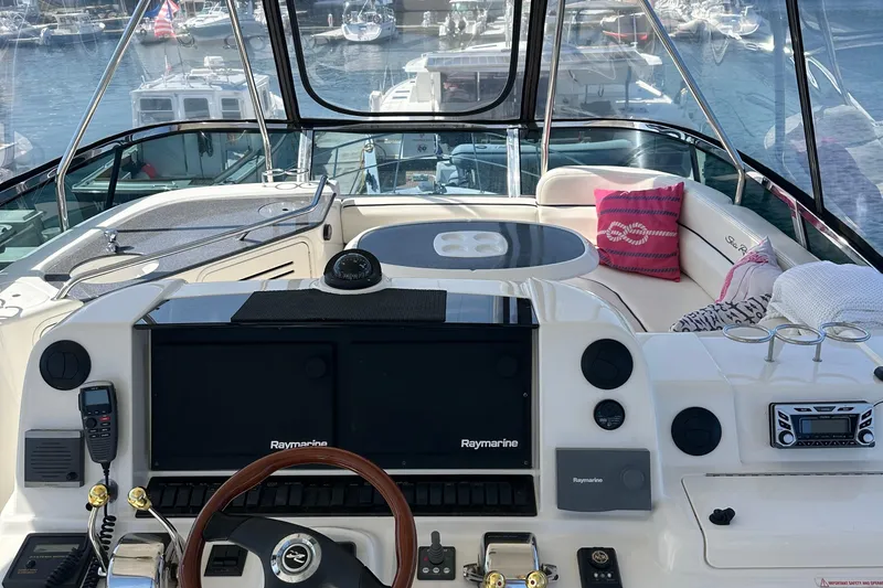 Slide: The Image of 2005 Sea Ray 500 Sedan Bridge yacht cockpit with navigation equipment and seating area. - 9