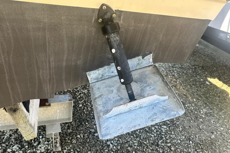 Slide: The Image of Trim tab of a 2006 Sea Ray 260 Sundancer boat on gravel surface. - 13