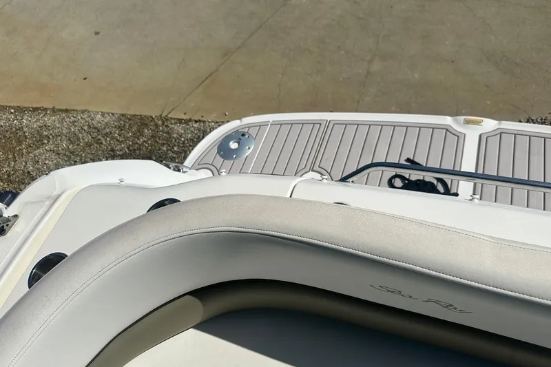 Slide: The Image of 2006 Sea Ray 260 Sundancer boat deck with cushioned seating and railing. - 17