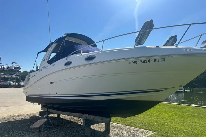 Slide: The Image of 2006 Sea Ray 260 Sundancer boat on dry dock under clear blue sky. - 2