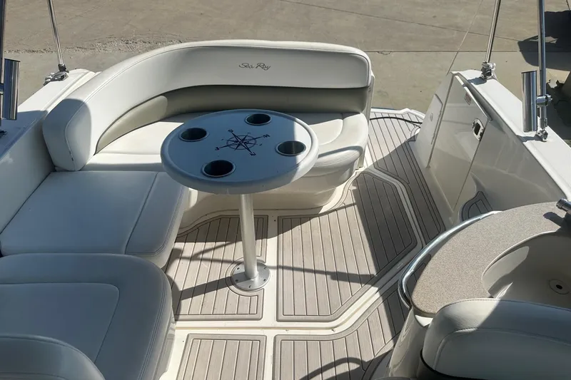 Slide: The Image of 2006 Sea Ray 260 Sundancer boat interior with seating and table, featuring a compass design. - 22
