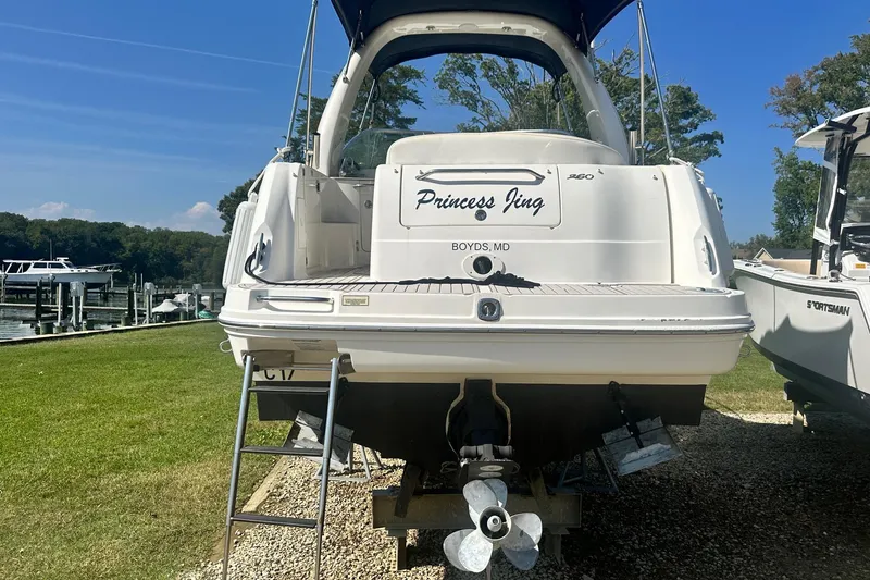 Slide: The Image of 2006 Sea Ray 260 Sundancer boat on land, rear view with ladder and propeller. - 4