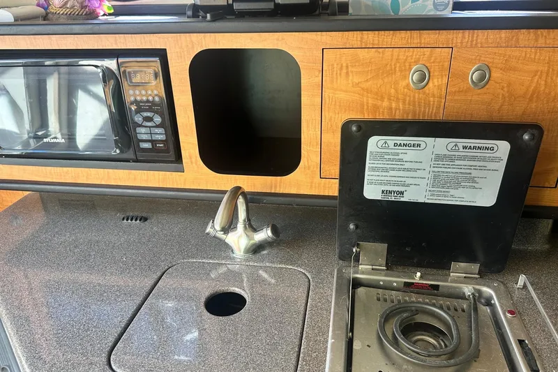 Slide: The Image of 2006 Sea Ray 260 Sundancer kitchen area with microwave, sink, and stove. - 42