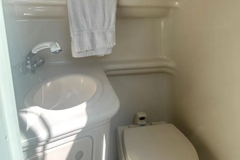 Slide: The Image of Compact bathroom in 2006 Sea Ray 260 Sundancer boat, featuring sink and toilet. - 44