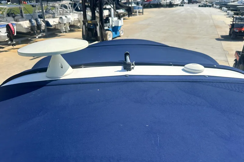 Slide: The Image of 2006 Sea Ray 260 Sundancer boat with blue canvas cover in a marina setting. - 55