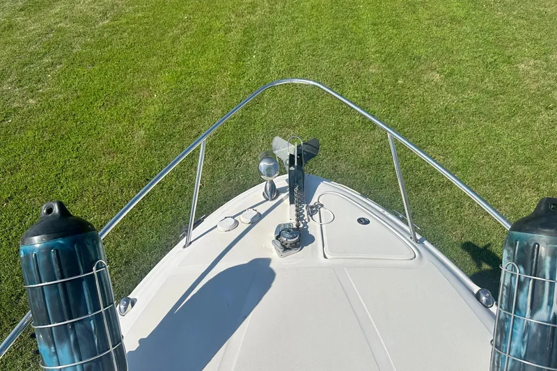 Slide: The Image of Bow view of 2006 Sea Ray 260 Sundancer on grass, featuring anchor and railings. - 58