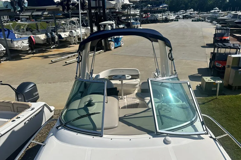 Slide: The Image of 2006 Sea Ray 260 Sundancer boat with open windshield, docked at a marina. - 60